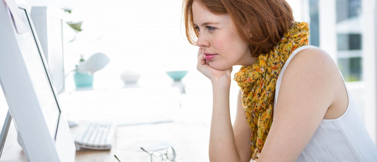 thoughtful hipster businesswoman concentrating on her computer