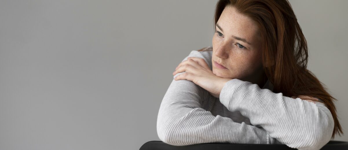 medium-shot-depressed-woman-sitting-chair